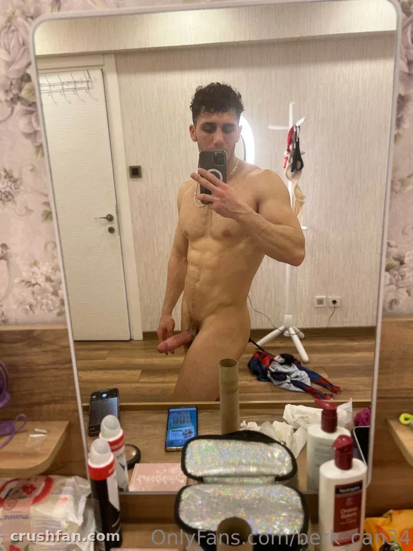 Mr. berk tomándose un selfie frente al espejo sin camisa en una habitación interior luminosa