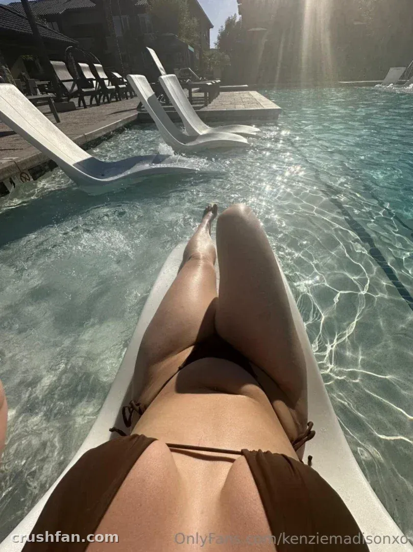 Creator entspannt auf einer Poolliege mit ausgestreckten Beinen über leuchtend türkisfarbenem Wasser im Sonnenlicht