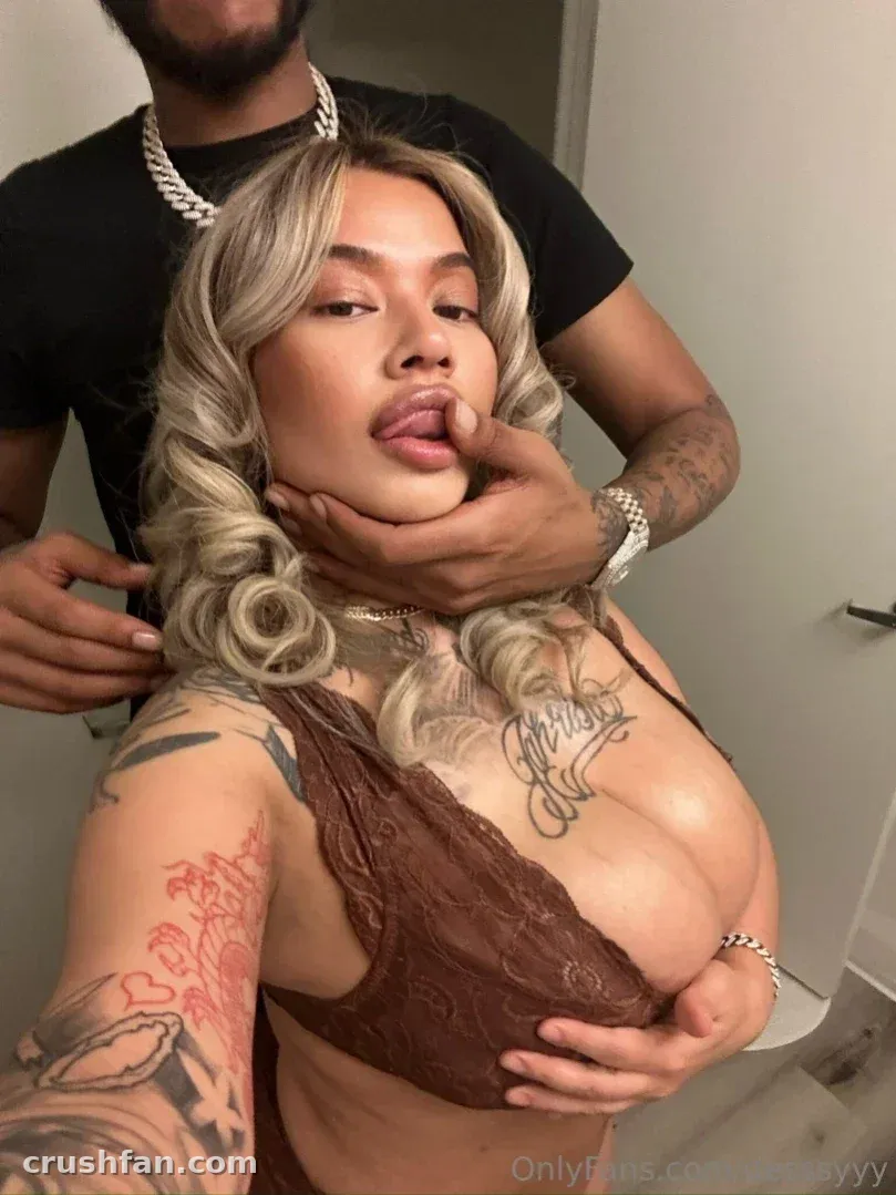 Creator in a brown lace top posing indoors with a playful expression
