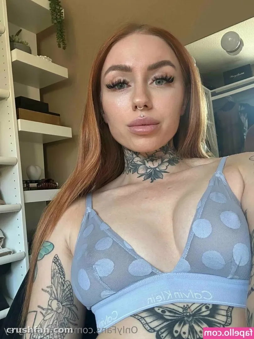 Creator in a light blue polka-dot bralette posing for a close-up mirror selfie indoors