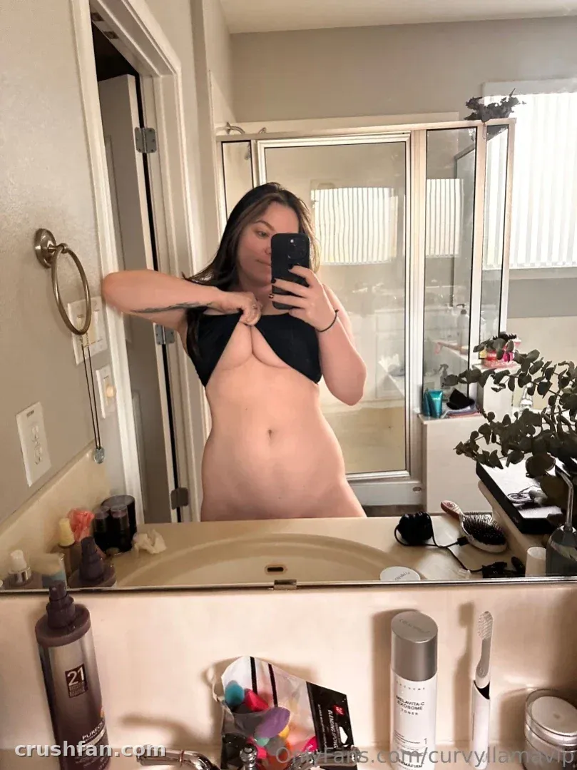 Creator taking a mirror selfie in a bright bathroom with toiletries on the counter