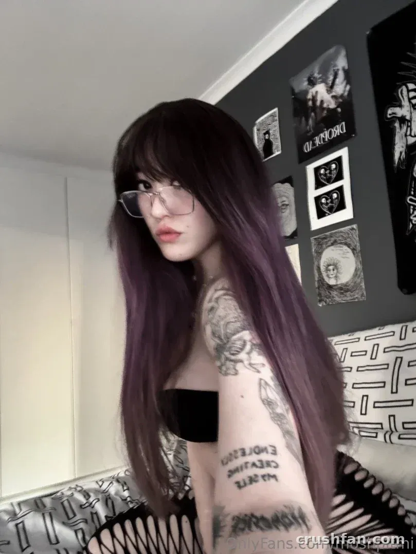 Miya ✄ con largo cabello morado y gafas en un top negro en interiores