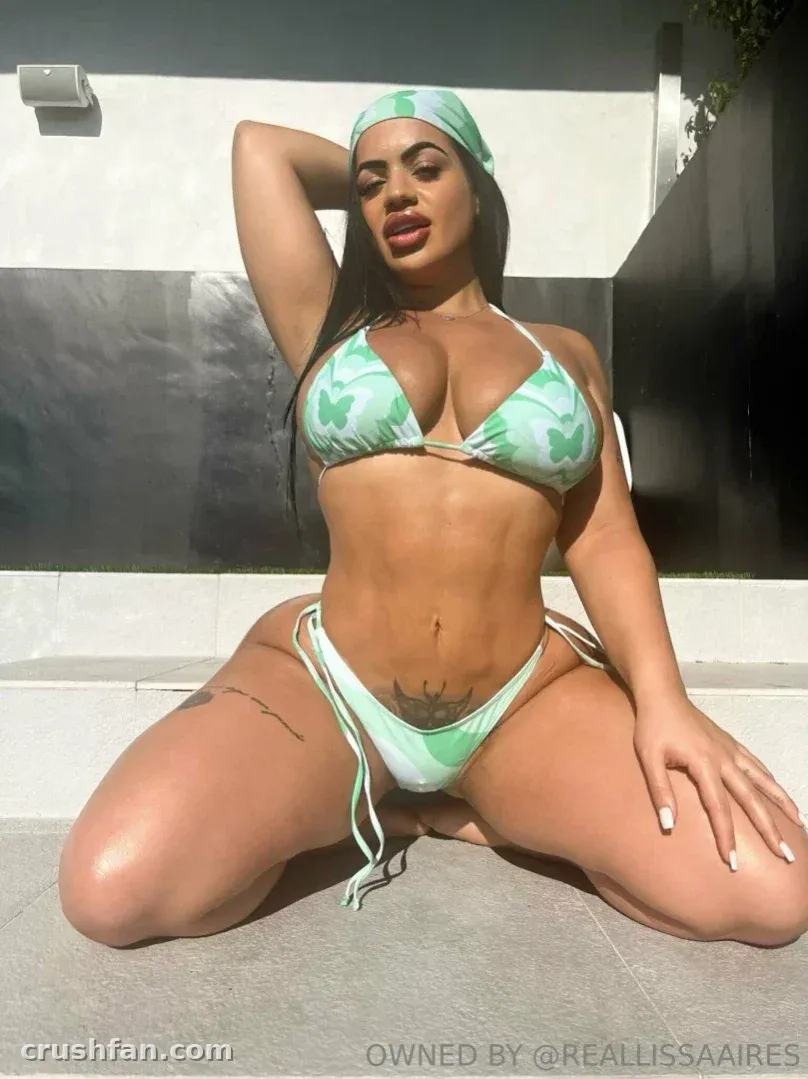 Lissa Aires en bikini vert menthe agenouillée en extérieur sous une lumière vive