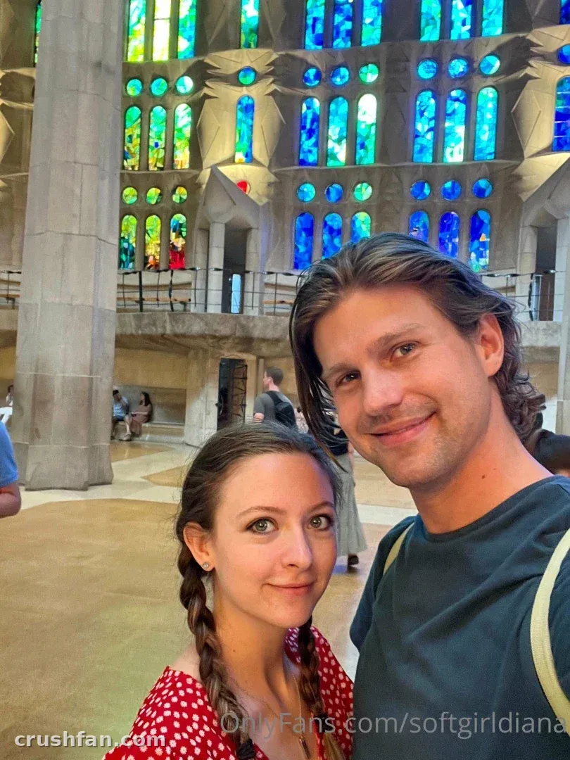 Diana und Damien machen ein Selfie in einer Basilika mit bunten Buntglasfenstern.