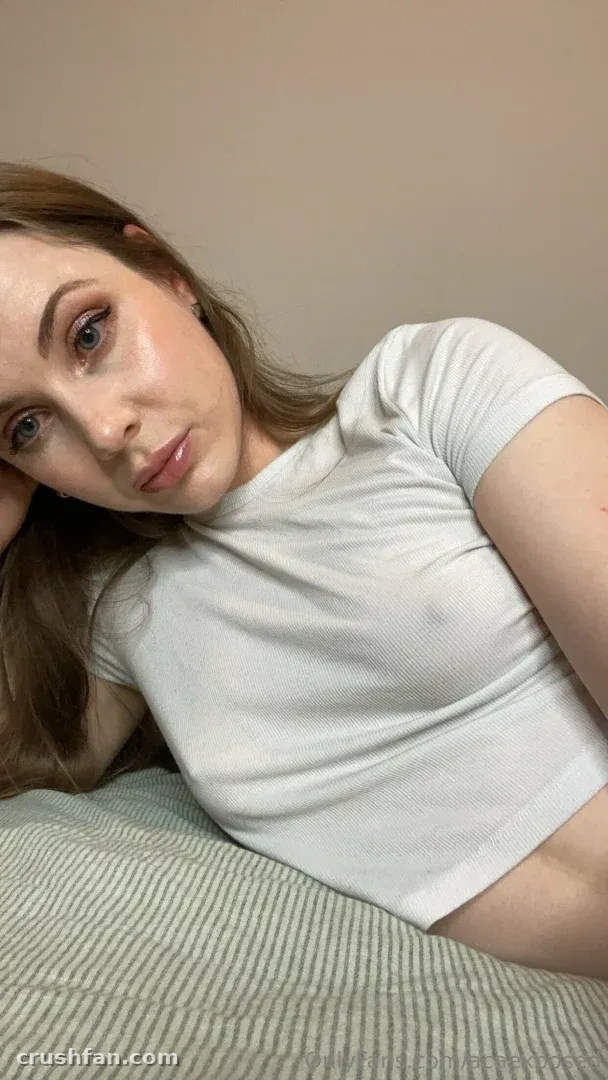 Creator en haut blanc reposant sur un lit rayé contre un mur beige