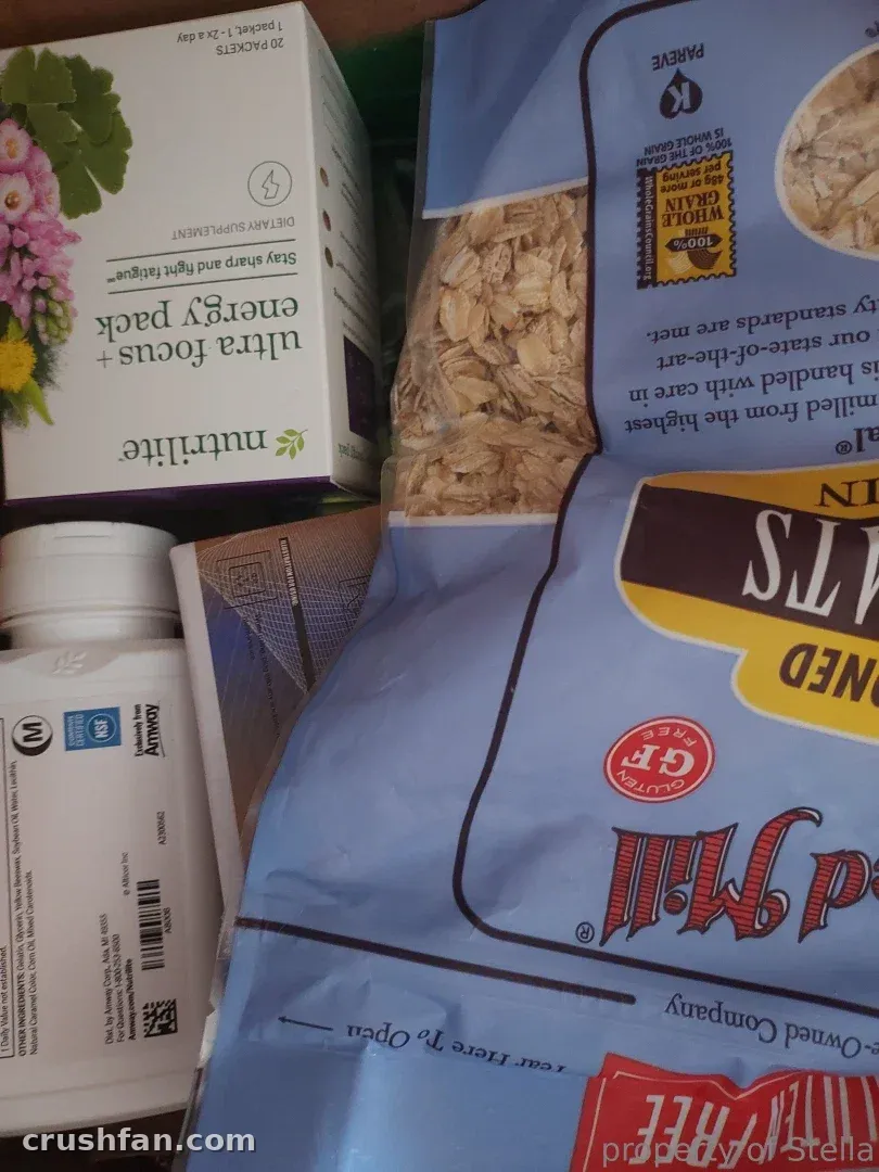 Primer plano de una caja de suplementos y una gran bolsa de avena sobre una superficie.