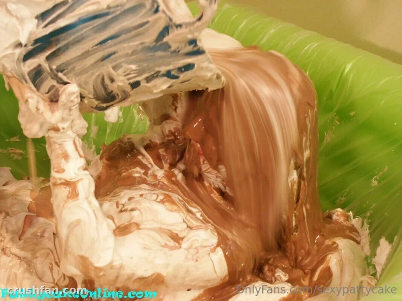 Sexy Pattycake covered in whipped cream and chocolate syrup against a green background