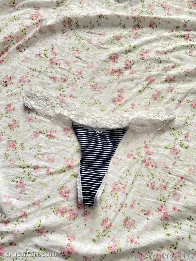 Floral bedspread with a white lace bralette and navy striped brief arranged on top