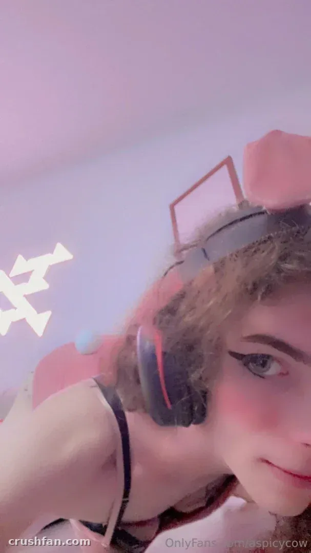 Close selfie of a woman with headphones against a pastel pink background