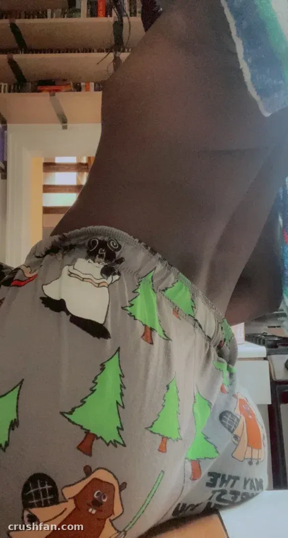 Vanniall in patterned loungewear with pine tree and bear motifs, photographed indoors from a low angle.