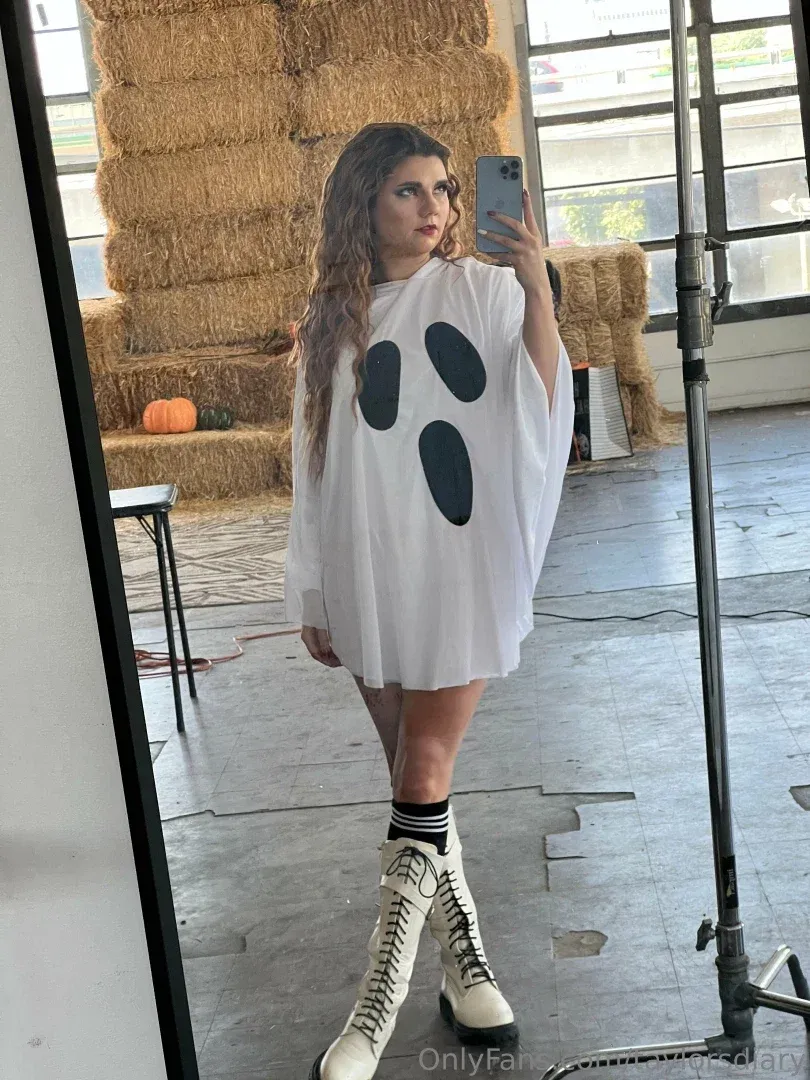 Taylor’s diary com uma fantasia branca de fantasma tirando uma selfie no espelho em um estúdio.