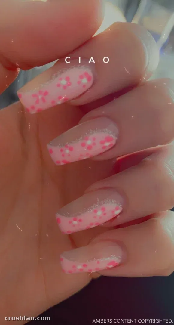 Close-up de uma mão com arte de unhas floral rosa longa