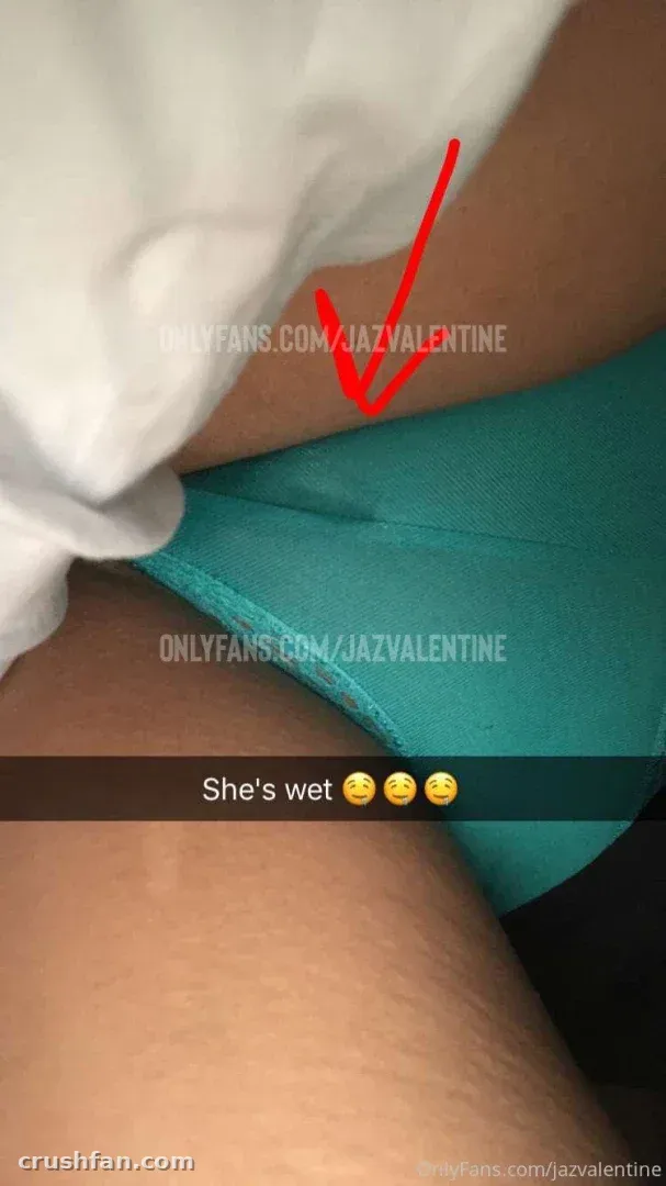 Close de lingerie em tom verde-azulado contra uma blusa branca repuxada, com uma seta vermelha desenhada na imagem