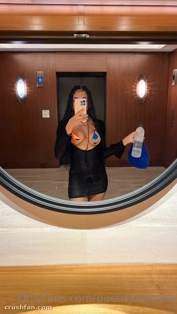 Creadora con un vestido negro tomándose una selfie en el espejo en una habitación con paneles de madera.