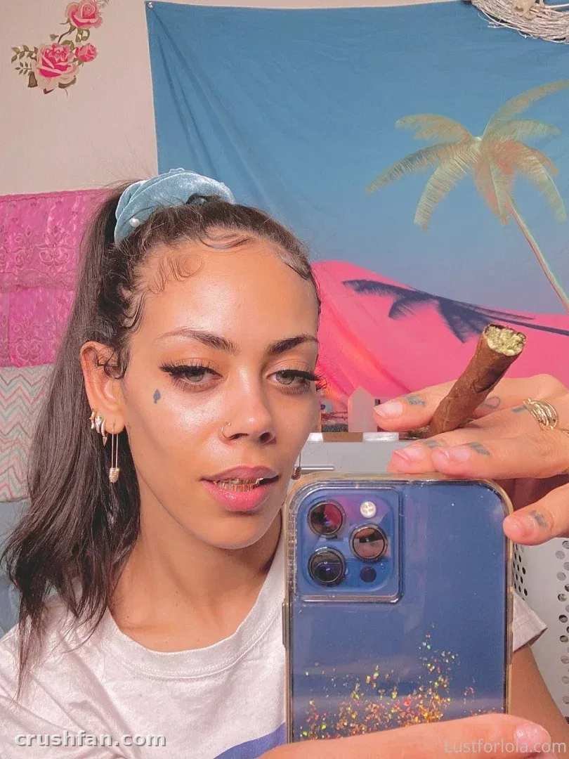 Creator in a white top and blue headband holding a glitter-filled phone case in front of a mirror.