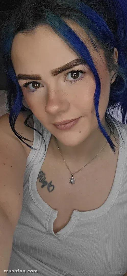 Selfie en gros plan de Chantelleh23 avec des cheveux bleus et un débardeur blanc.