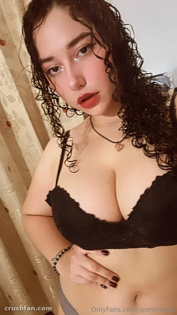 Jasmine Leal con cabello oscuro rizado en un bralette de encaje negro en interiores