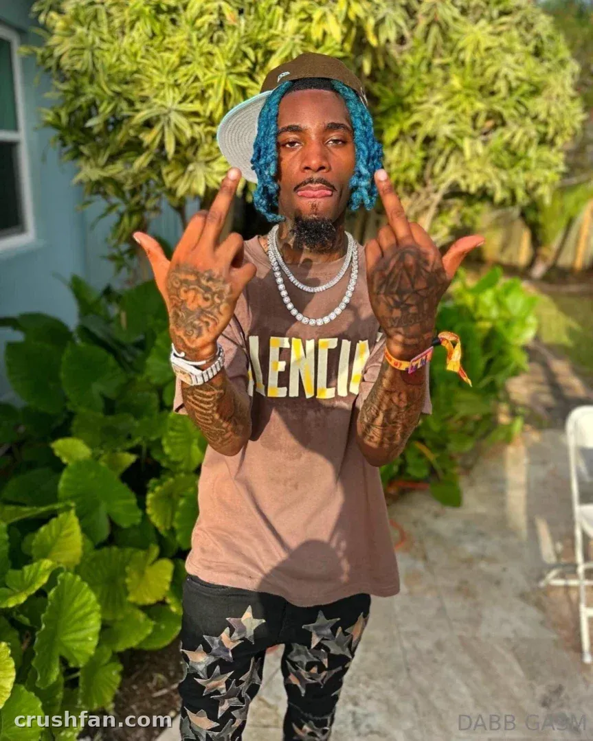 DABB LAND in a brown graphic t-shirt and star-print pants outdoors among green plants