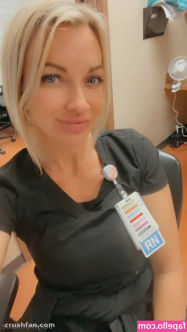 Creator in dark scrubs with a colourful badge reel in an indoor selfie.