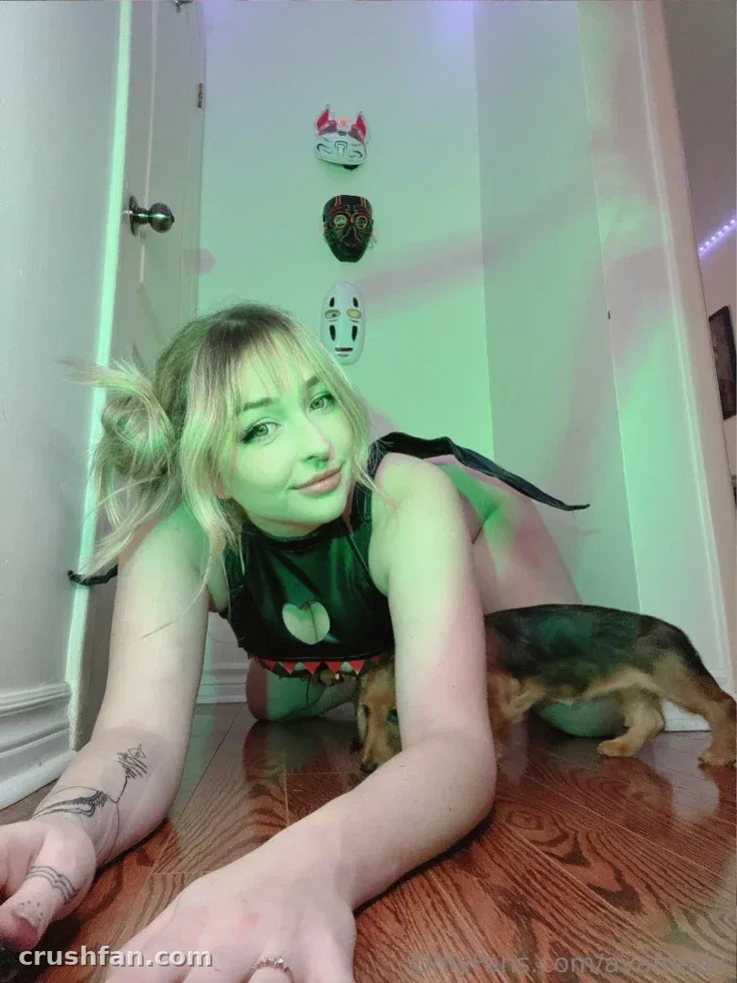 Ava deitada em um piso de madeira sob luz verde com um cachorrinho por perto