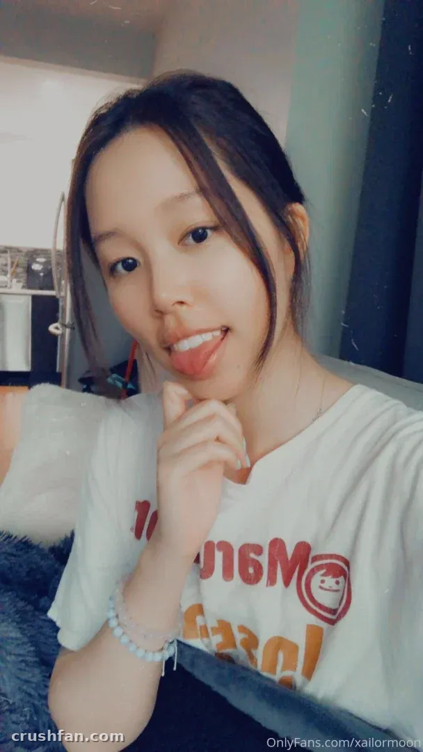 Criadora com uma camiseta gráfica branca posando para uma selfie próxima em ambiente interno