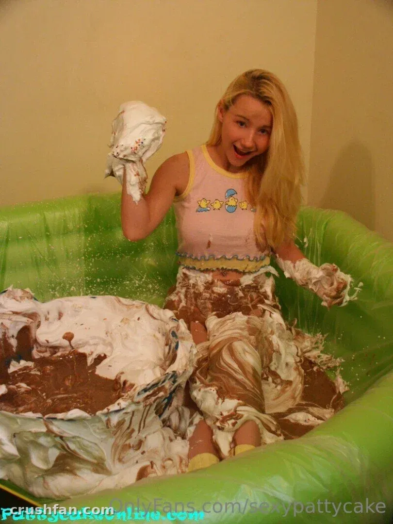Sexy Pattycake smiling in a green inflatable pool filled with chocolate and cream.