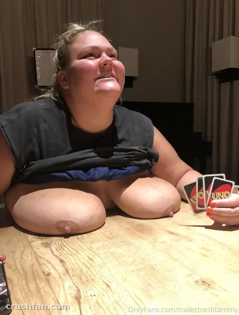 Chelcie Lynn holding playing cards at a wooden table indoors