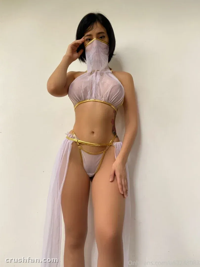 Keysi.love com um conjunto de duas peças transparente em branco e dourado contra uma parede branca.