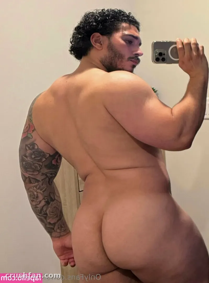 Diego Grant taking a mirror selfie with a floral tattoo on his arm.