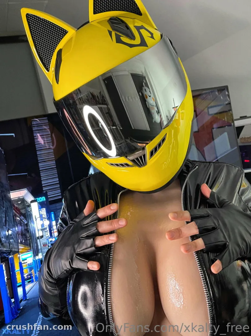 Creador con un casco amarillo con orejas de gato y chaqueta de cuero negra posando de noche.