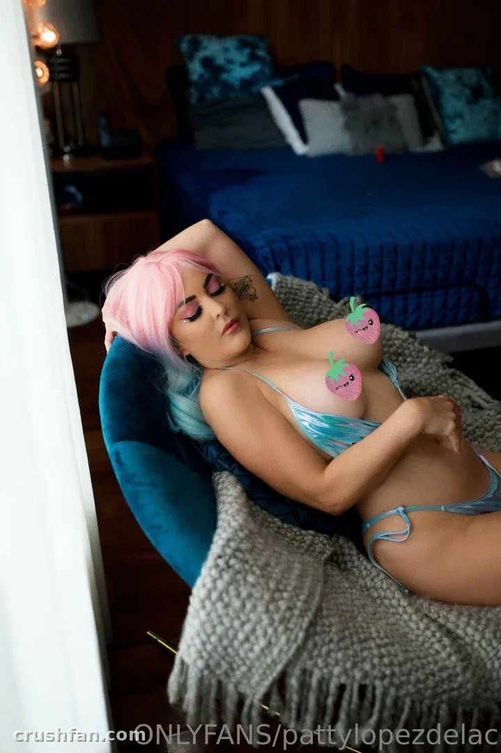 Patty se détendant sur une chaise bleu canard avec une couverture grise dans une chambre aux tons bleus