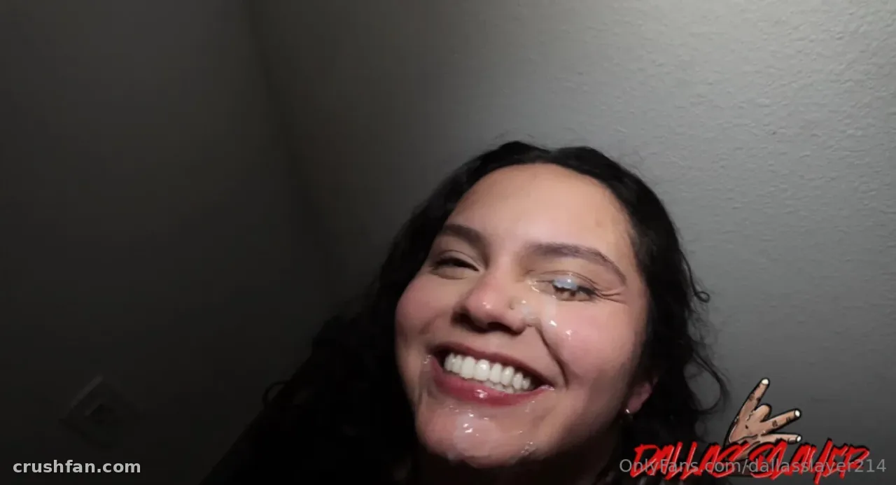 214 Dallas Slayer souriant dans un selfie indoor en gros plan contre un mur gris