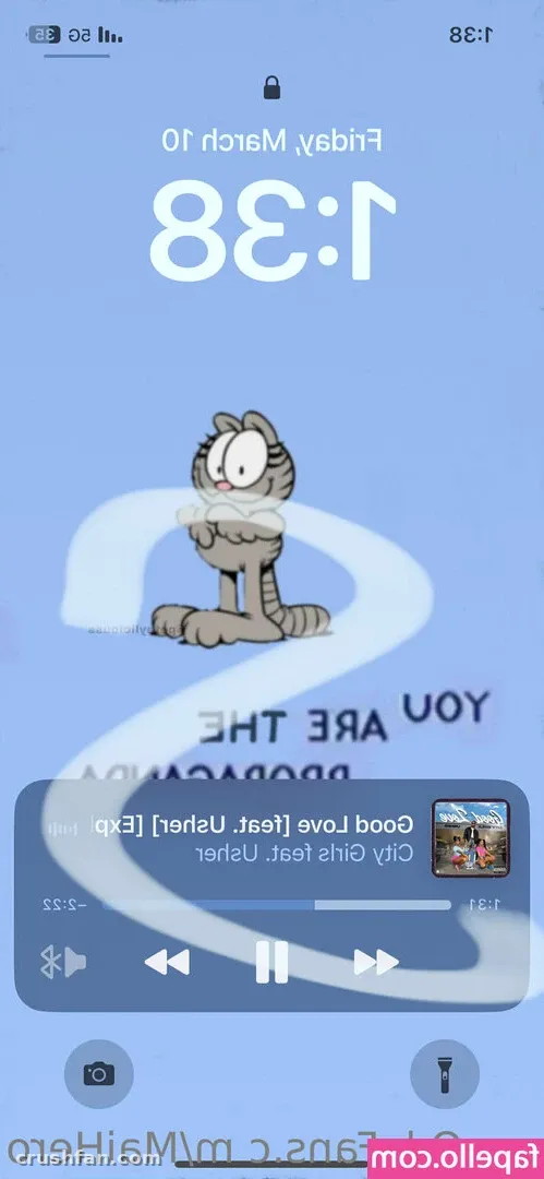 Tela de bloqueio de celular espelhada com um gato de desenho animado e player de música em fundo azul
