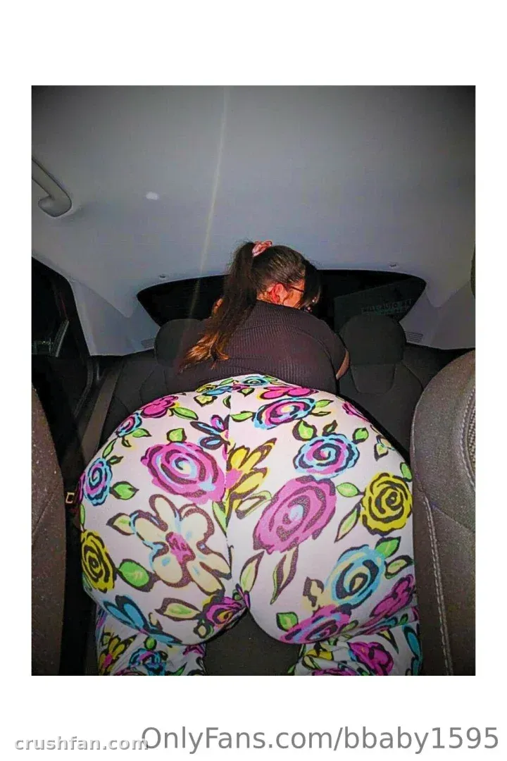 Miss Bunny leaning forward in a car wearing colourful floral leggings