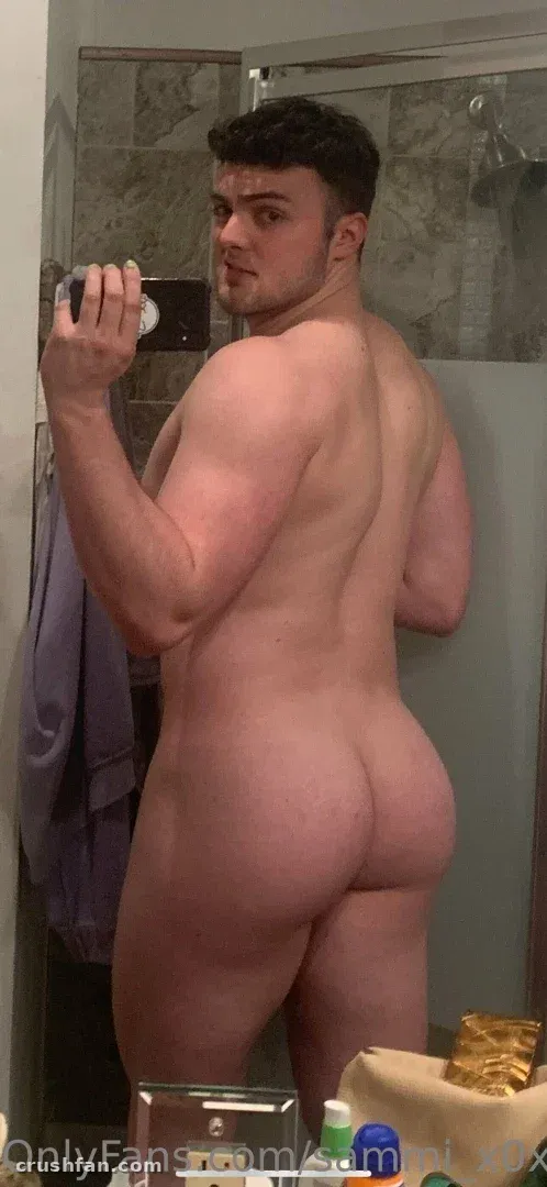Sammi prenant un selfie miroir nue dans une salle de bain aux murs carrelés.