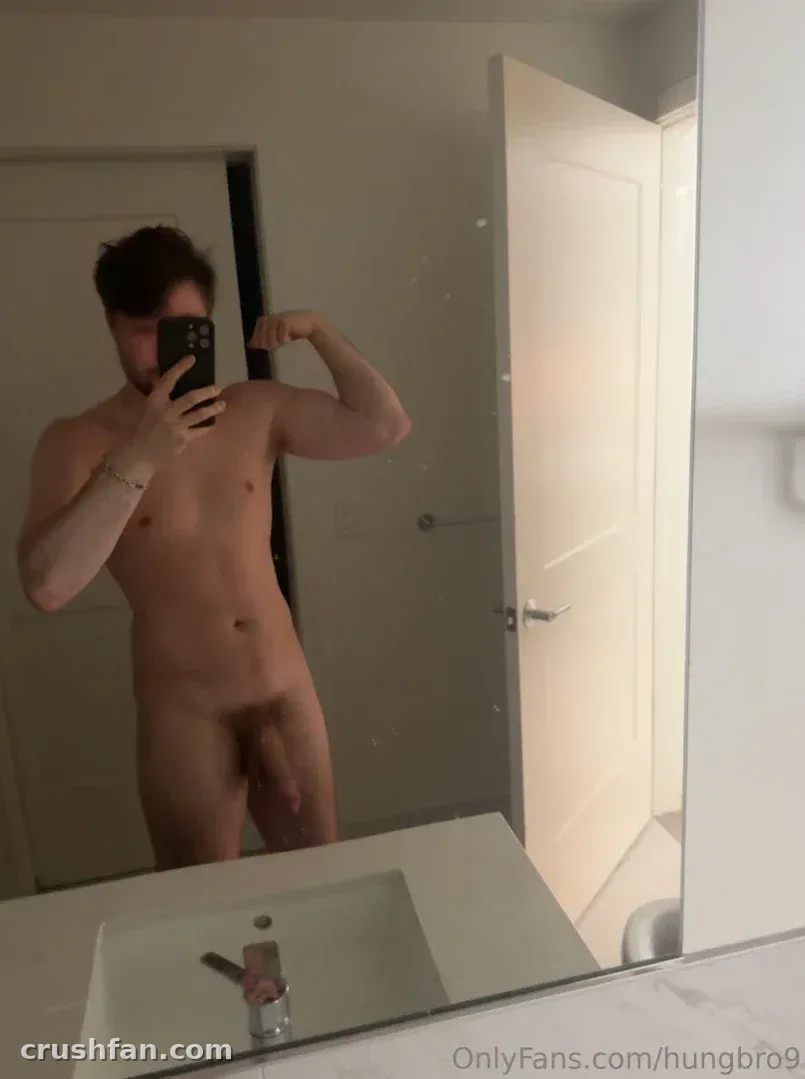 hungbro9 prenant un selfie miroir dans une salle de bain lumineuse avec des murs blancs et un lavabo.