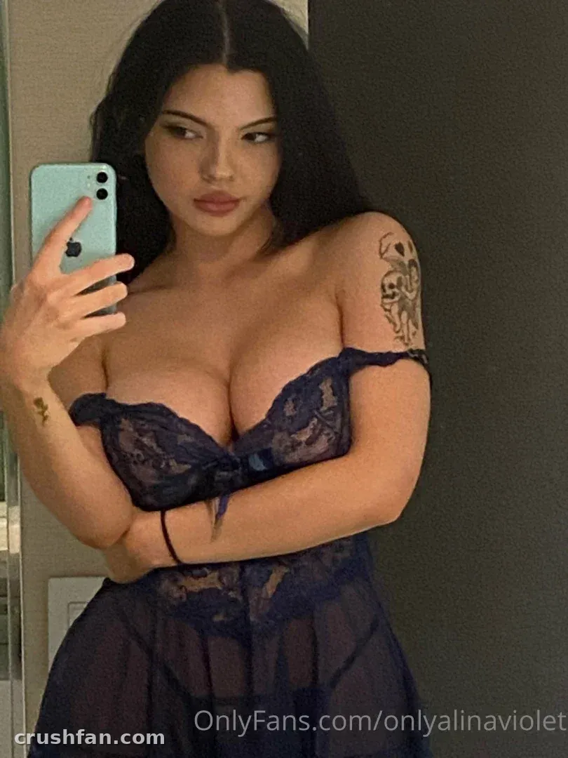 Alina Violet tomándose un selfie de espejo con lencería de encaje azul oscuro en interiores