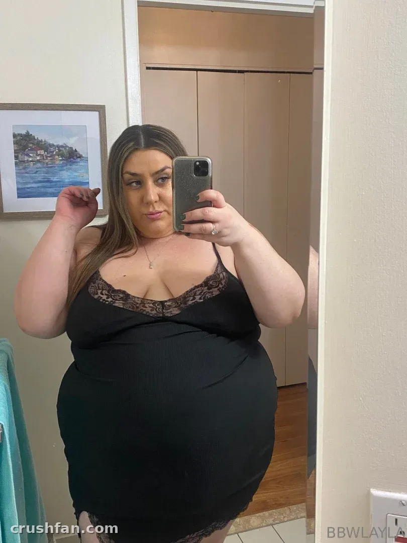 BBW Layla in einem schwarzen Slip-Kleid mit Spitzenbesatz beim Spiegel-Selfie in Innenräumen
