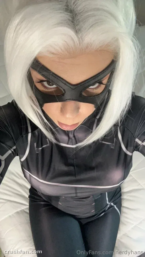 Criadora com um body preto e prateado e máscara, olhando para a câmera