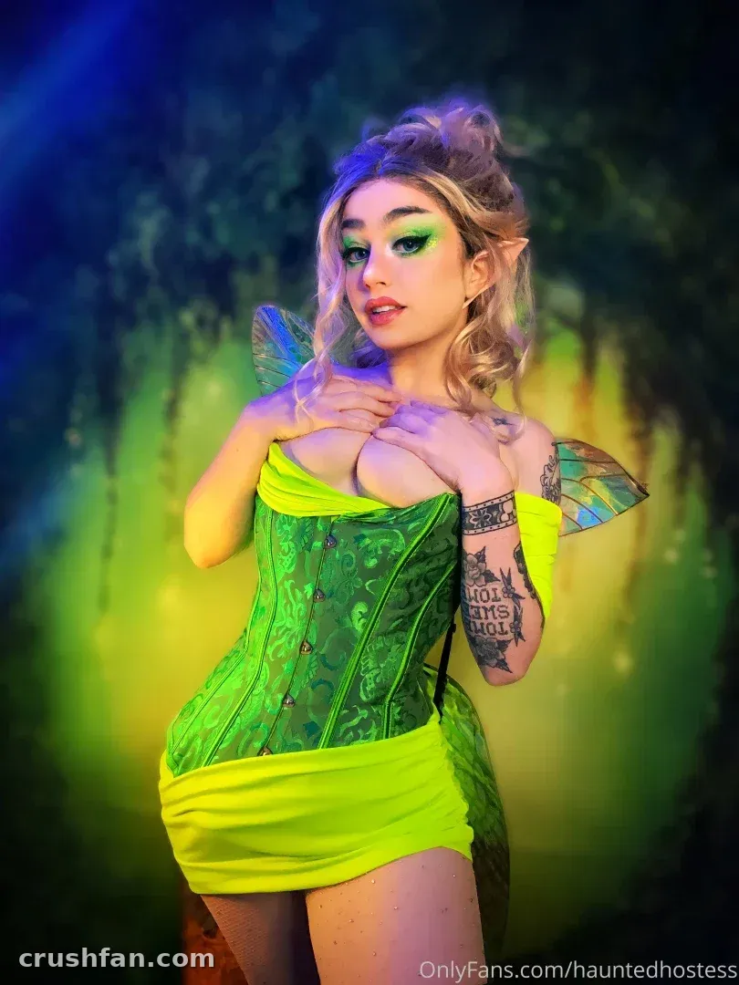 Haley Quinn en un cosplay de hada verde con alas y llamativo maquillaje de ojos