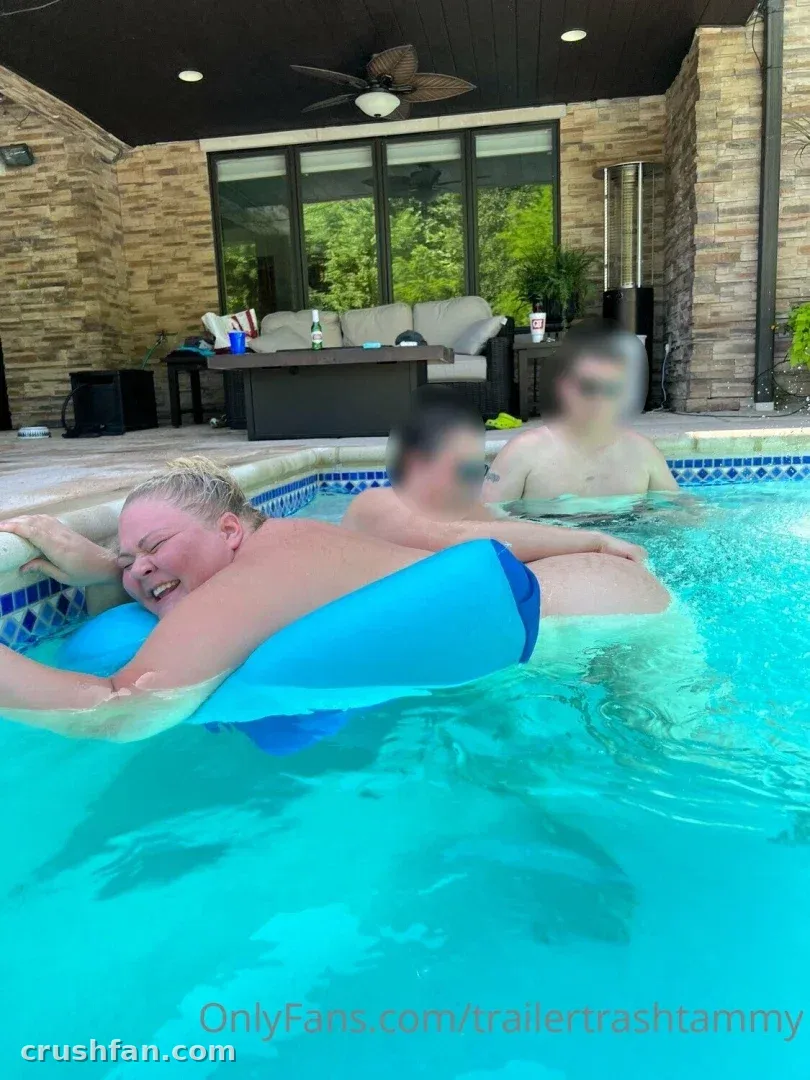 Chelcie Lynn flotando en una piscina azul con un flotador inflable azul en un entorno de patio trasero.