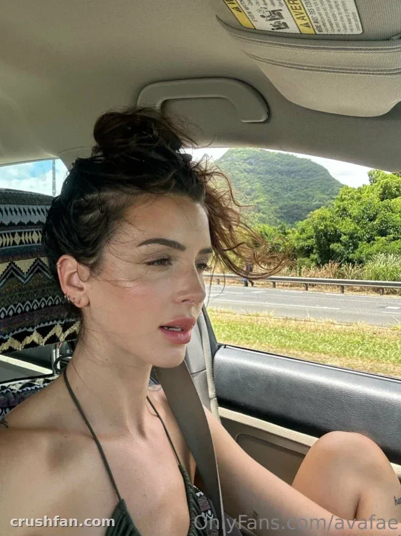 Ava Ruru in a car looking out at green hills on a sunny day