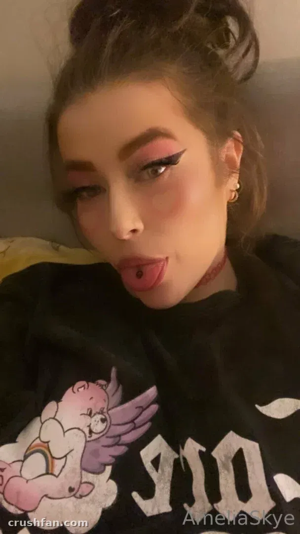 Amelia Skye in einem schwarzen Sweatshirt mit Cherub-Print, die in einem nahen Selfie ein verspieltes Gesicht macht