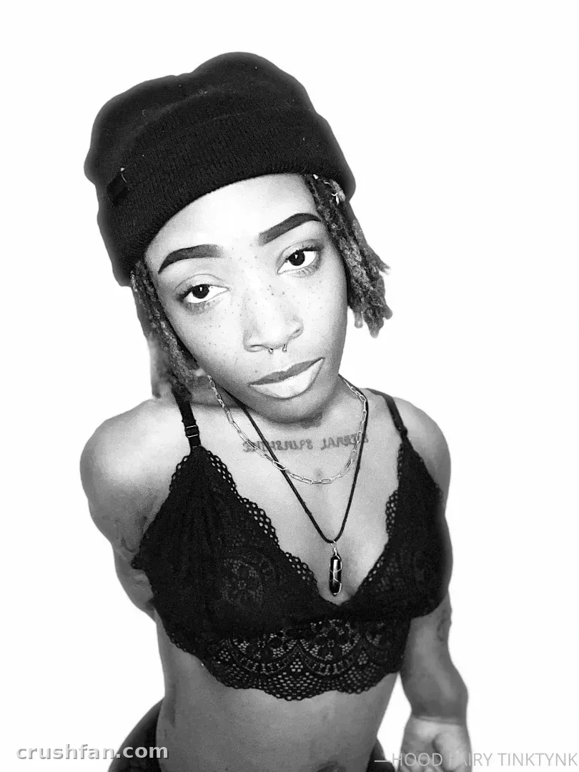 Creator in a black beanie and lace bralette in a black-and-white studio portrait
