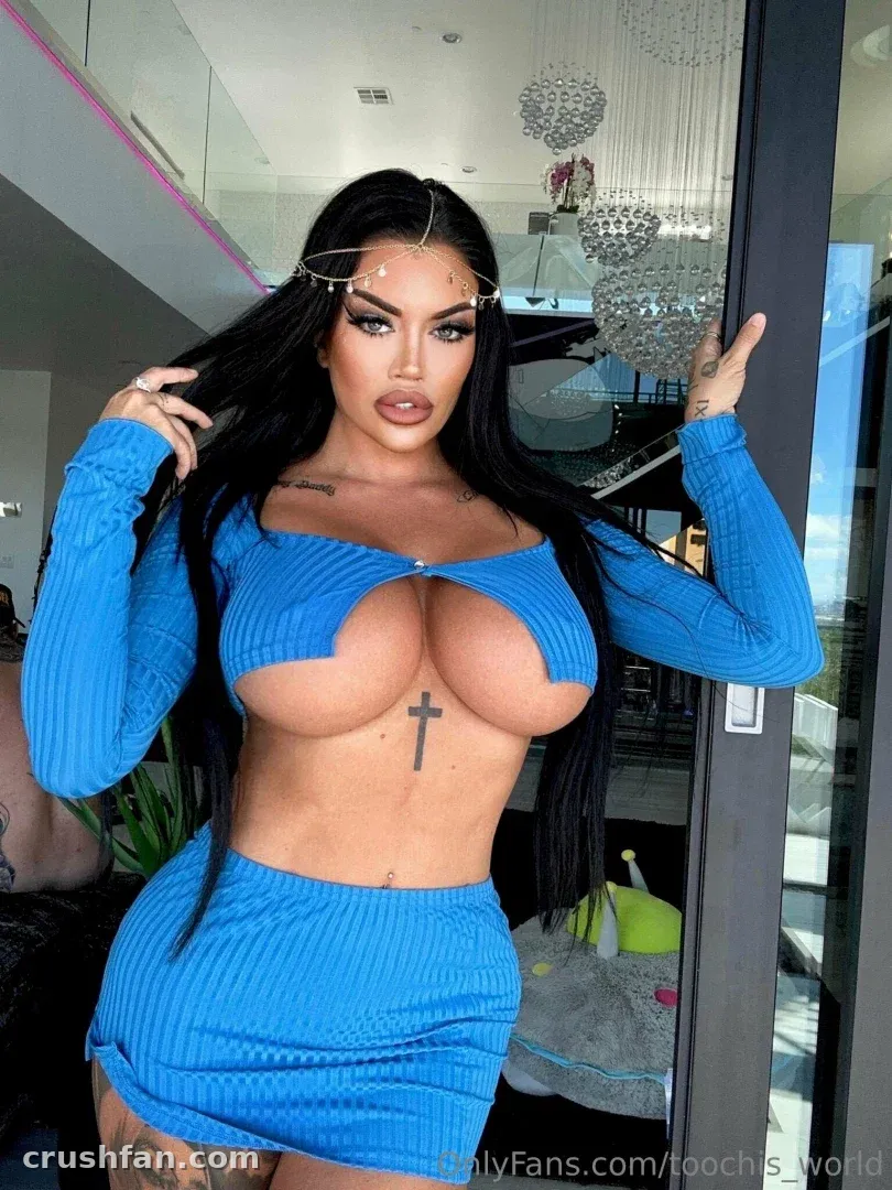 Toochi Kash dans un ensemble deux pièces bleu côtelé posant en intérieur près de suspensions en verre.