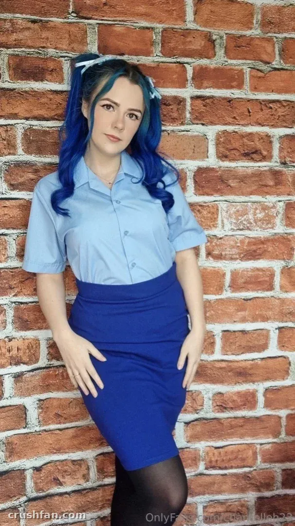 Chantelleh23 NO PPV in a blue shirt and skirt standing by a brick wall.