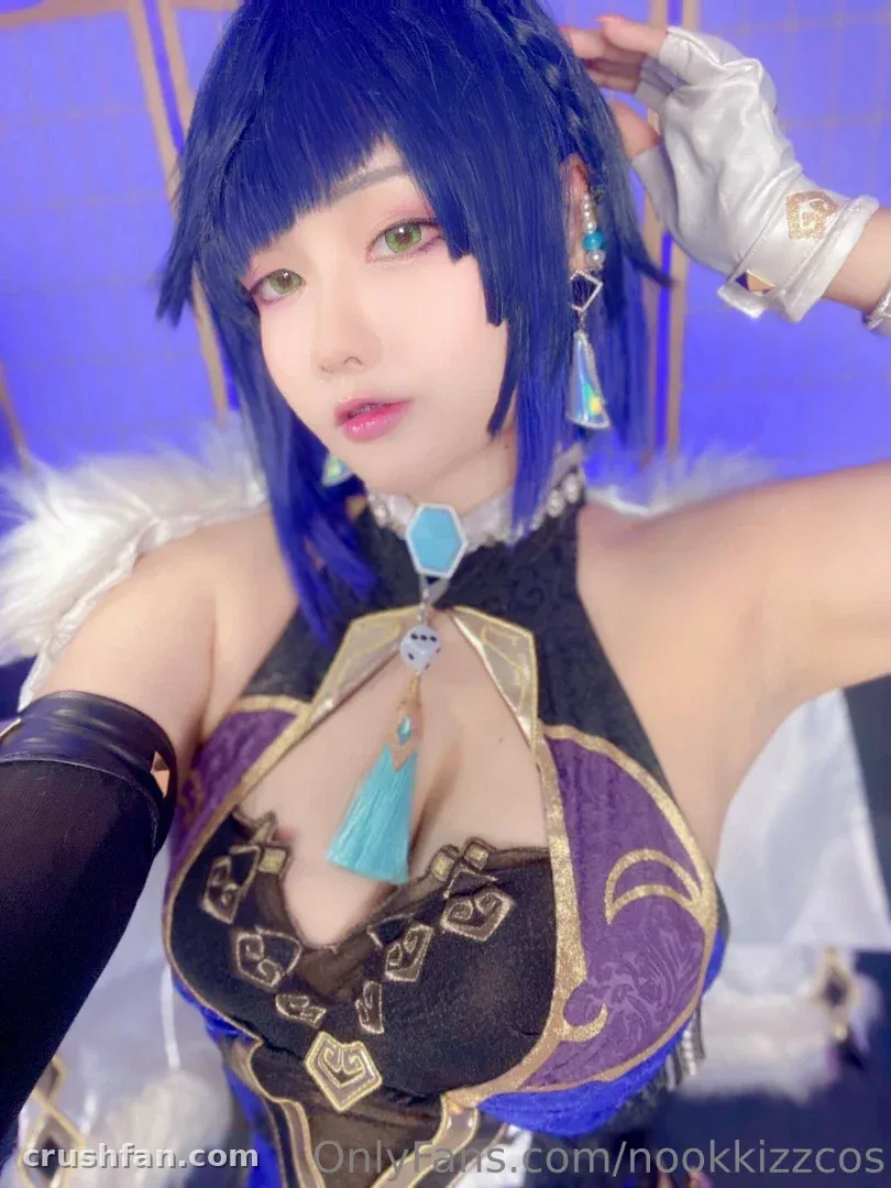 NookkizzCos in a blue wig and ornate purple and gold cosplay costume
