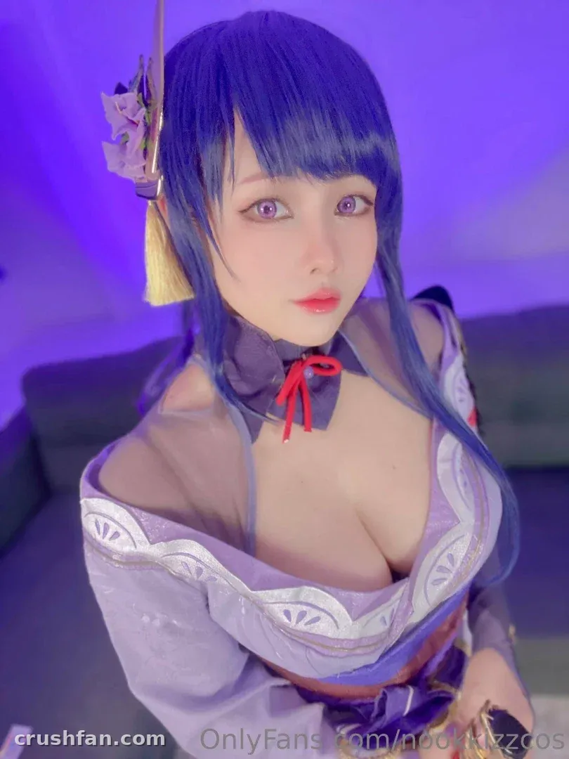 NookkizzCos in a lilac cosplay outfit with blue hair against a violet backdrop