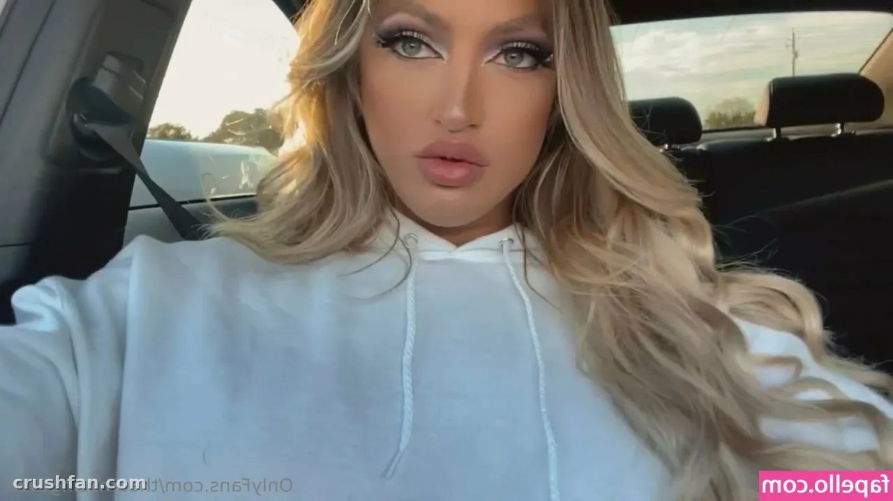 Evee Marie in einem weißen Hoodie beim nahen Selfie in einem Auto