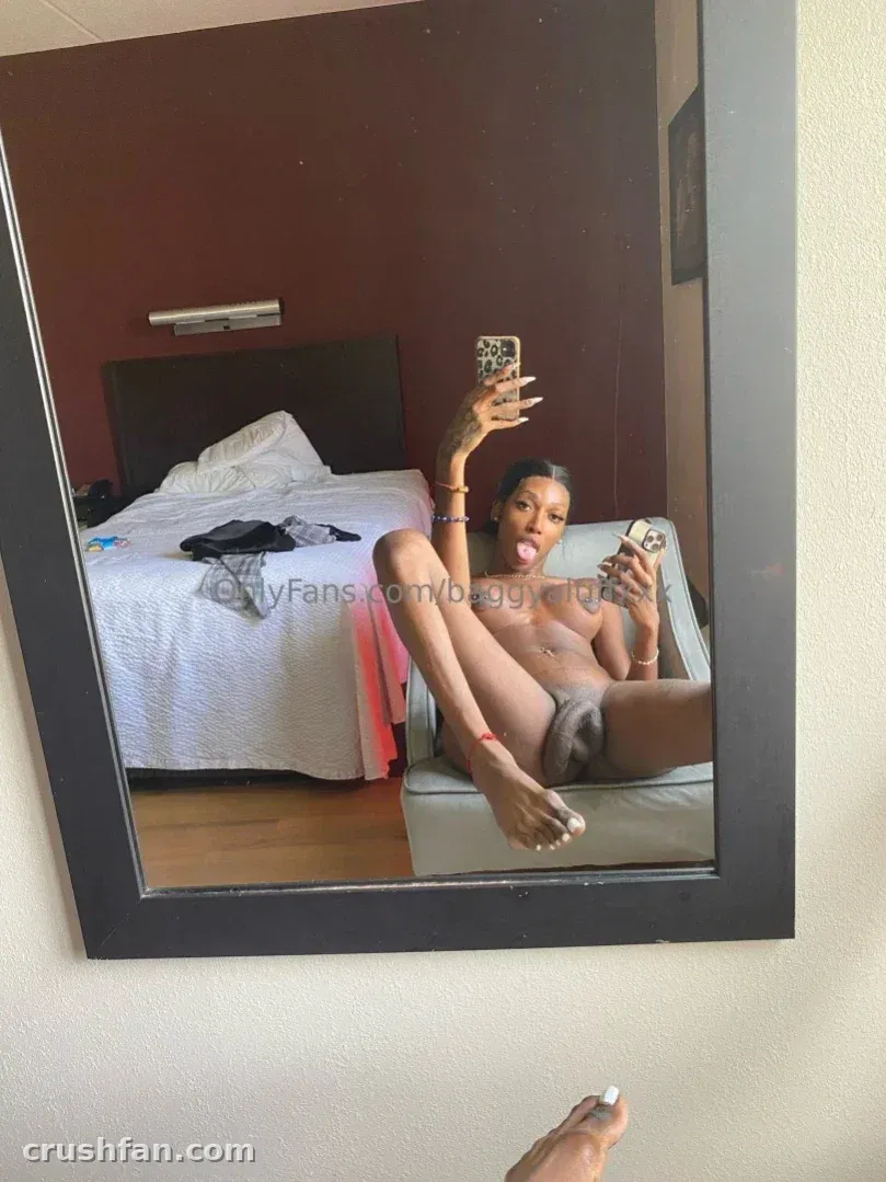 mAmi-Tiff assise sur un canapé dans une chambre d'hôtel prenant un selfie dans le miroir.